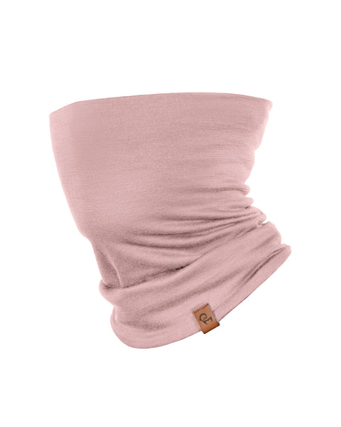 A product shot of a dusty pink tubular neck gaiter displayed upright against a pure white background. The fabric shows natural folds and draping, and there is a small brown leather logo patch visible near the bottom right edge.