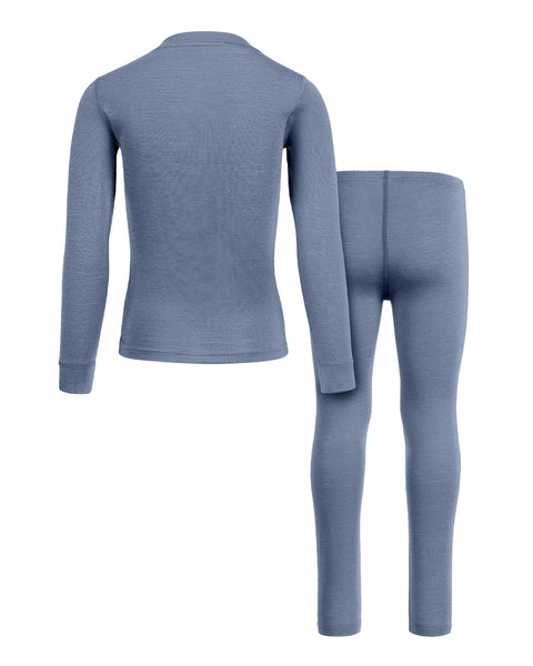 A back-view product shot of a children's two-piece base layer set, including a long-sleeved top and leggings, in a heathered dusty blue color. The items are laid flat against a pure white background, with the top positioned slightly to the left and overlapping the leggings on the right. The center back seam of the leggings is clearly visible.
