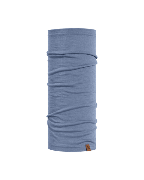 A product image of a long, tubular dusty blue neck gaiter displayed vertically against a plain white background. The soft fabric features natural horizontal folds and a small brown logo tag attached to the bottom right edge.