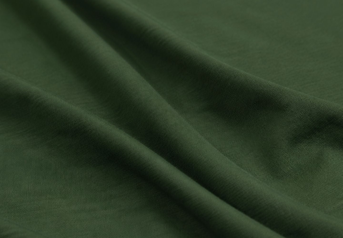 A close-up shot highlights the smooth texture and gentle folds of a dark olive green fabric. The soft lighting emphasizes the material's fine weave and subtle sheen.