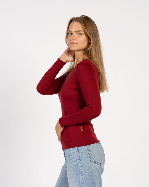 Side profile of women’s red Merino wool thermal top – 160 crew neck shirt
