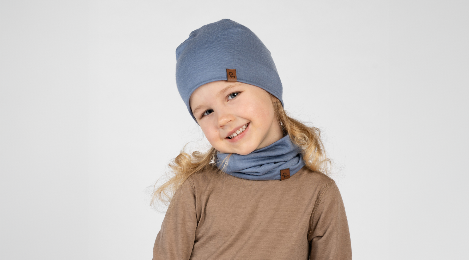 a boy wearing the menique kids' merino wool and cashmere accessory set of beanie and gloves in dark gray color.