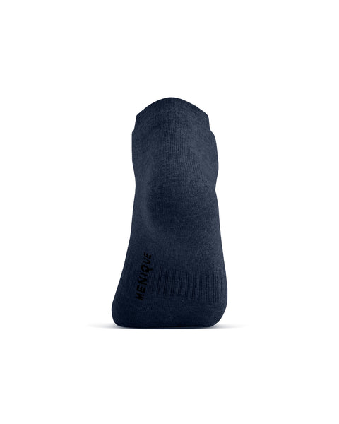 A back view of a dark blue ankle sock on a foot model, showing the heel and the word "MENIQUE" printed vertically on the lower left side.