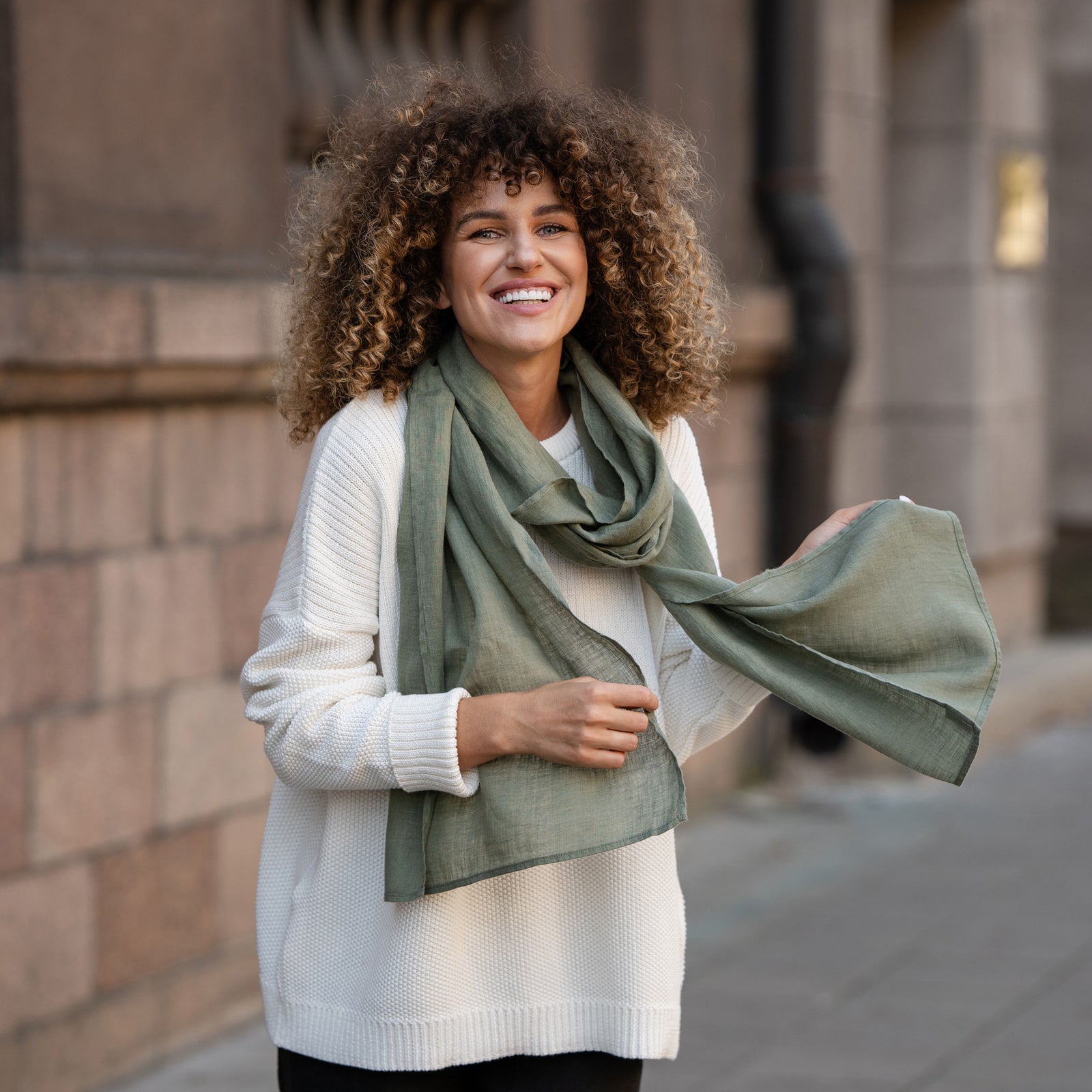 Elegant plum-colored European washed linen scarf draped over white knit sweater showing lightweight fabric texture by Menique