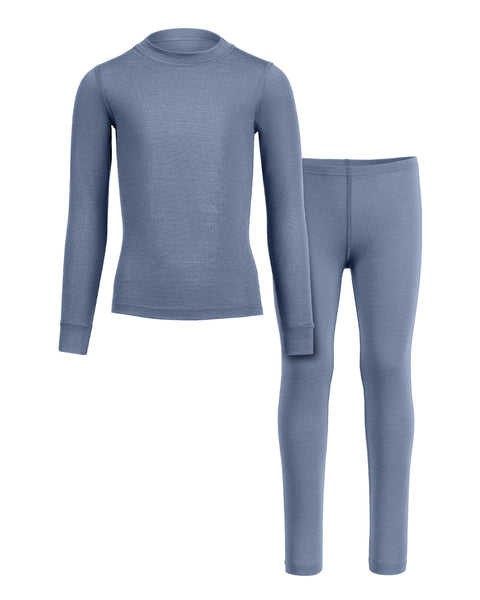 A front-view product shot of a children's two-piece base layer set featuring a long-sleeved top and leggings in a heathered dusty blue color. The top has a simple crew neckline and cuffed sleeves, while the leggings show an elastic waistband and a center front seam. The items are displayed flat against a pure white background, with the top on the left slightly overlapping the leggings on the right.