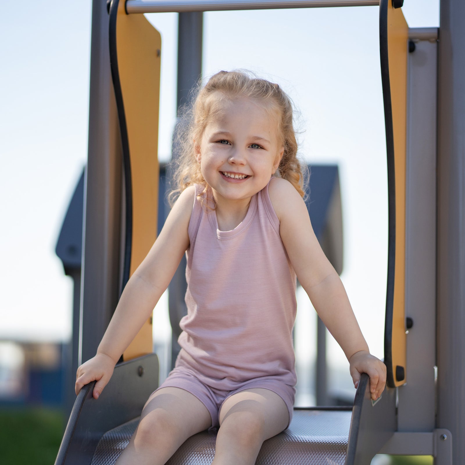 Front view of a kids' sleeveless top in a solid dusty pink color, displayed flat against a white background. It features a simple crew neckline with ribbed trim around the collar and armholes.