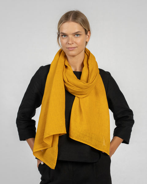 Mustard yellow European washed linen scarf elegantly draped over black outfit, showcasing lightweight fabric texture - Menique