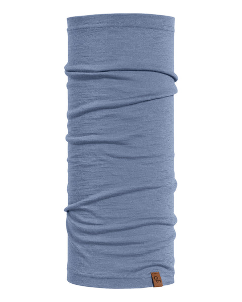 A long, tubular knitted neck gaiter in a heathered dusty blue color, displayed vertically against a pure white background. The fabric is slightly scrunched and gathered, showing its soft drape. A small, square brown leather logo patch is attached near the bottom right hem.