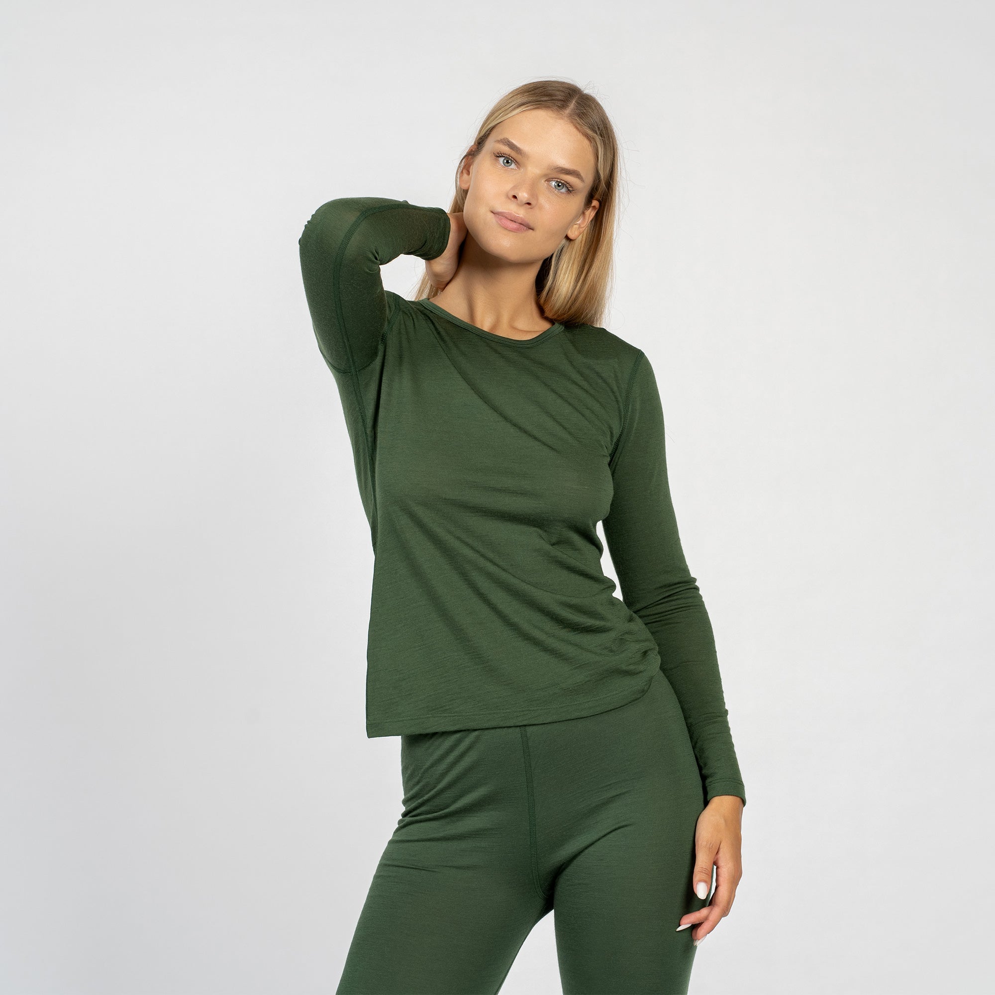The menique women's merino wool dark green long sleeve top matched with menique dark green bottoms, from the front.