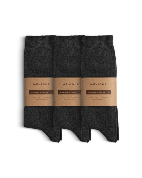 Set of three pairs of dark gray men’s cotton socks, neatly folded and wrapped with Menique’s minimalist brown kraft paper packaging labeled ‘Premium Quality.
