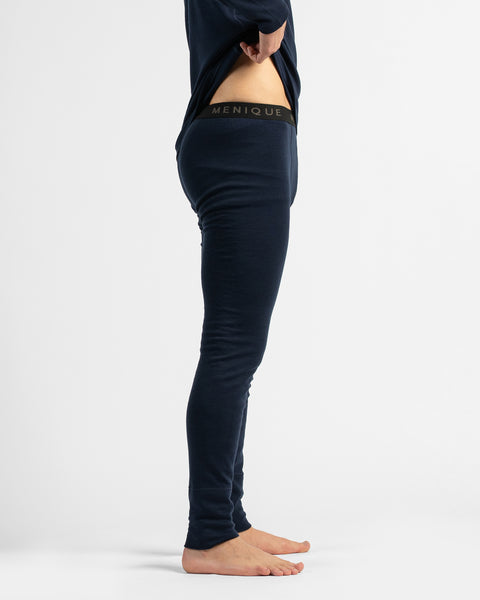 A cropped side view from the waist down showing a barefoot figure in dark navy thermal leggings and matching top.