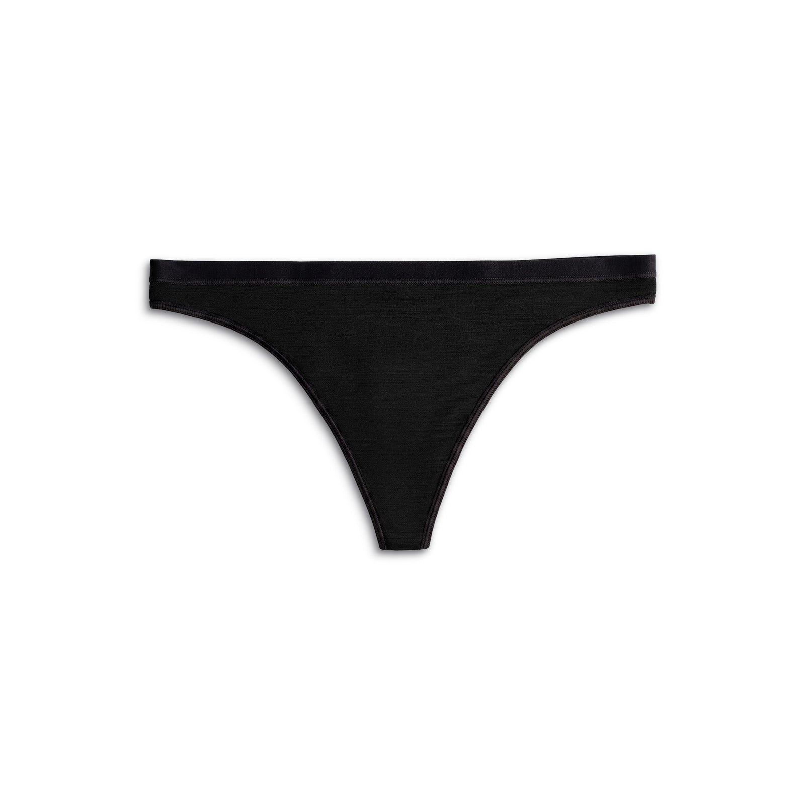 a woman on her knees on a bed, wearing the menique Women's Merino 160 Thong Briefs in Black color.