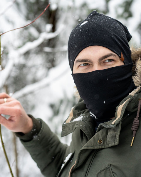 Menique Men's Merino Beanie and Gaiter Accessory Set worn by a man, in winter time. The set is in black color.