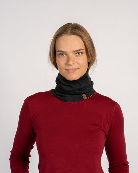 Woman in a red shirt with a dark gray knitted Merino wool gaiter covering the neck, front view.